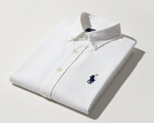 White dress shirt with a small logo on a light background